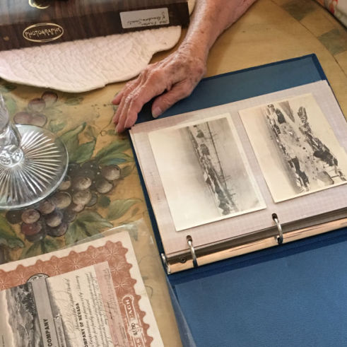 Private family collection of images and documents in folders across a table.