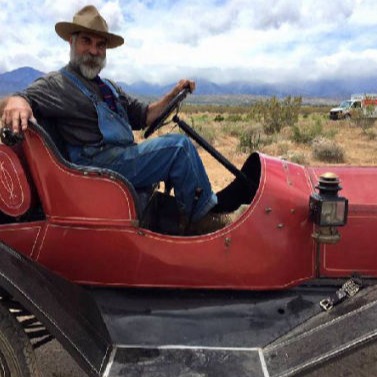 Paul Greenstein drives a vintage red vehicle from his collection